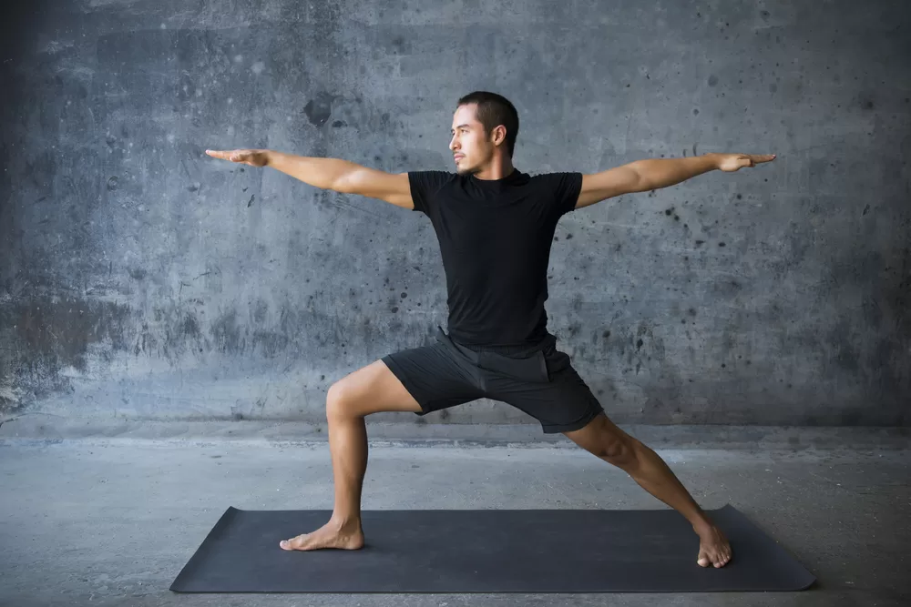 Man practicing yoga in cement studio