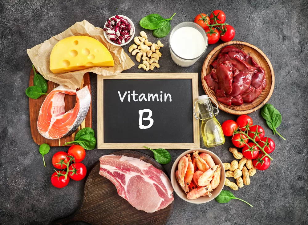 Vitamin B written on chalkboard with fresh food sources surrounding it